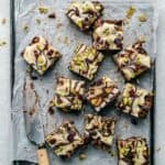 Christmas Rocky Road cut up on parchment paper on a tray, with a knife to the side.