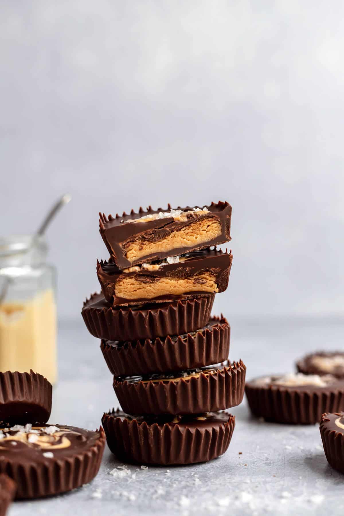 a stack of cashew butter cups with one cut in half to show the inside