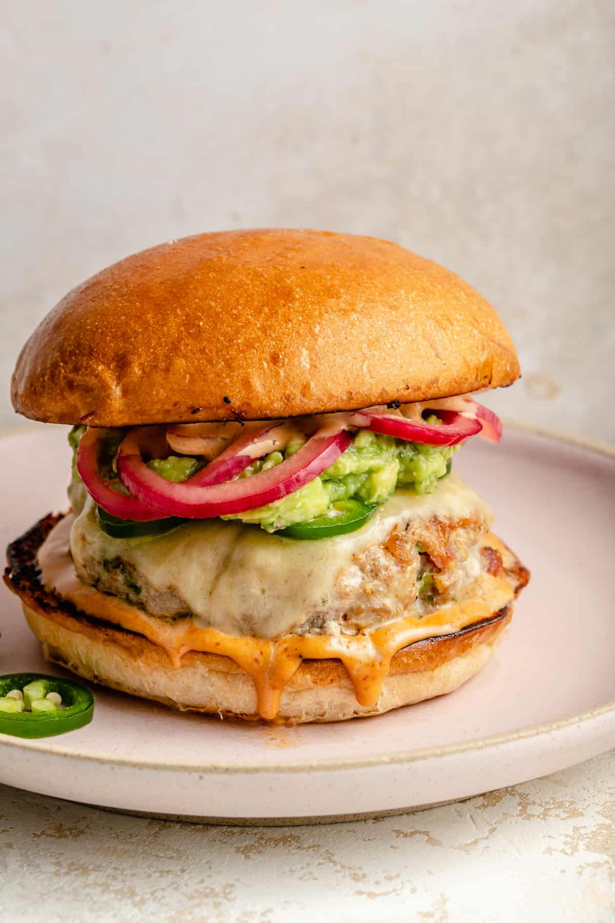 jalapeno turkey burger on a plate with toppings. 