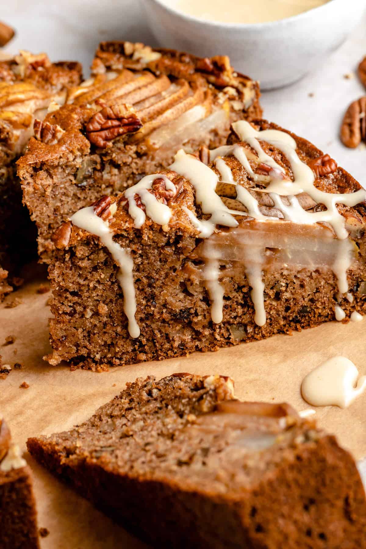 close up photo of a slice of cake that has been drizzle with glaze, the glaze is drizzling down the edge of the cake