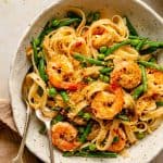 Bowl of pasta with shrimp, garlic and lemon with a spoon and fork