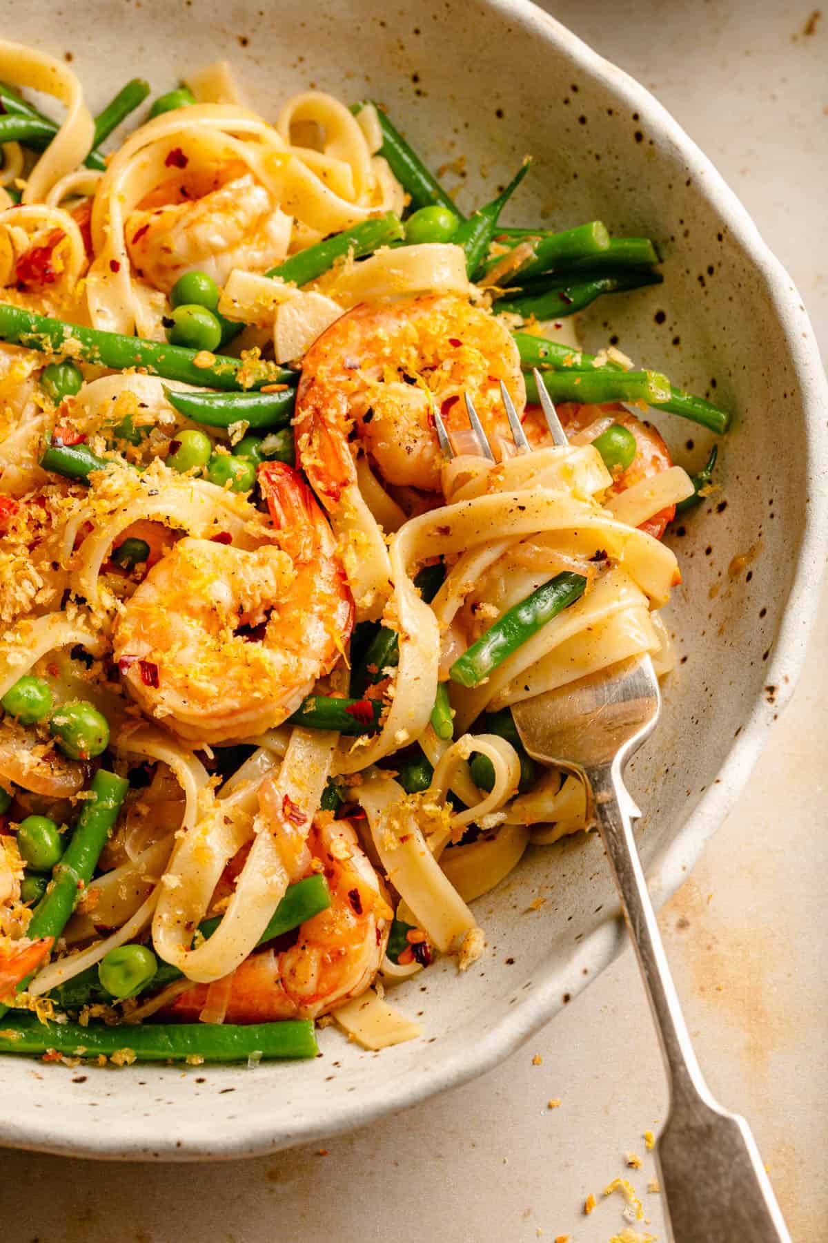 Lemon garlic shrimp pasta served in a bowl with pasta twisted onto a fork.