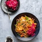 gochujang noodles with salmon in a bowl with cabbage on the top