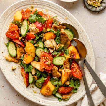 Nectarine salad served on a platter with two serving spoons.