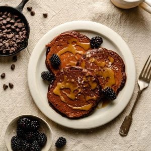 Chocolate pancakes on a plate drizzled with tahini maple syrup