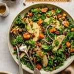 bowl of salad with forks and a dish of pecans on the side