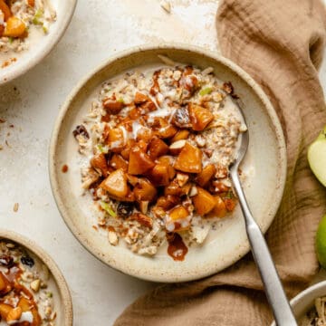 Apple cinnamon overnight oats in a bowl with apple cinnamon topping and a spoon.