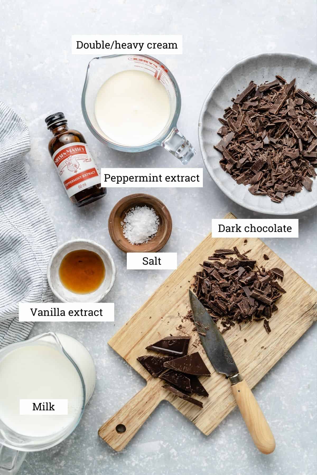 Ingredients for peppermint hot chocolate including, cream, chocolate, salt, vanilla extract and milk.