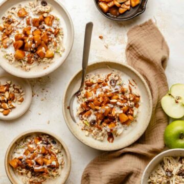 Various bowls of overnight oats with caramel apples on top a napkin and a spoon.