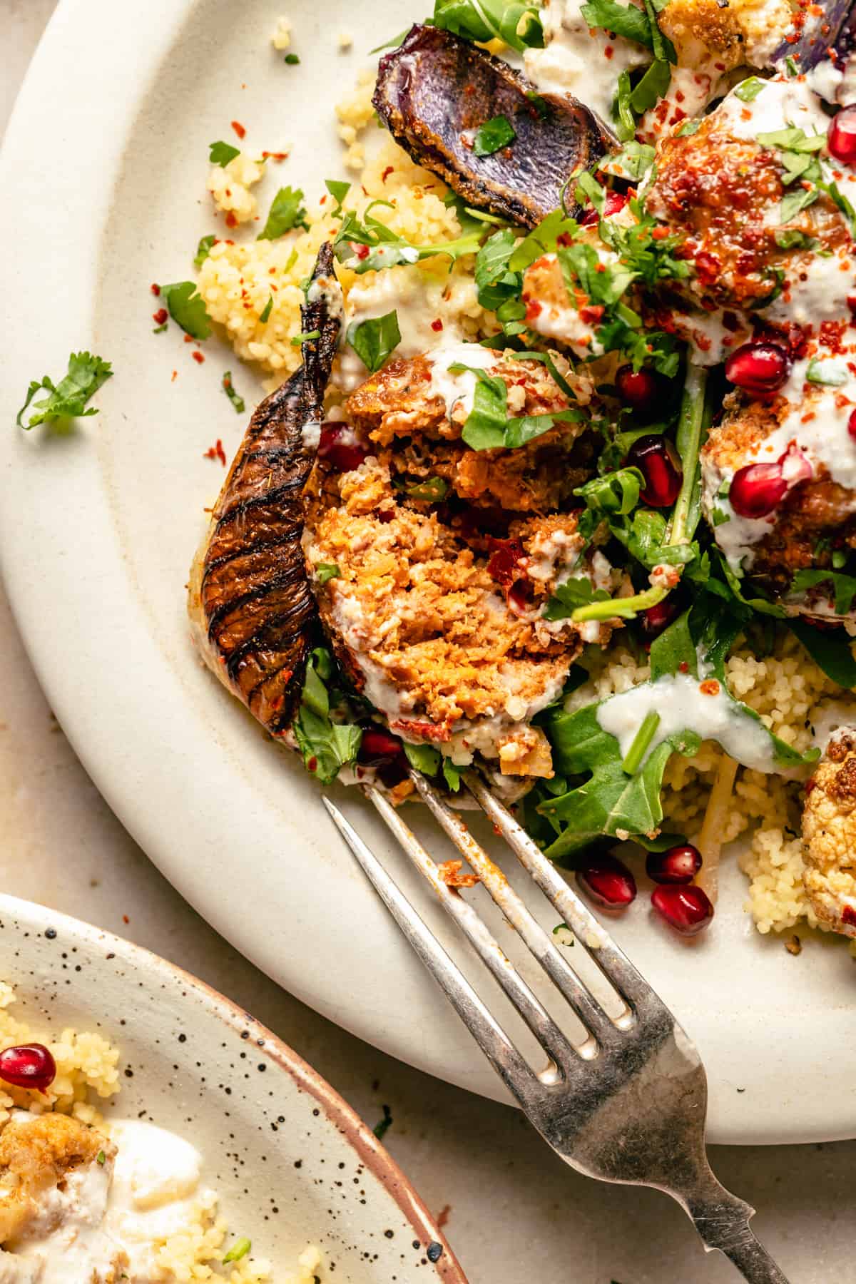 A close up of a baked turkey meatball broken up on a plate with a fork. 