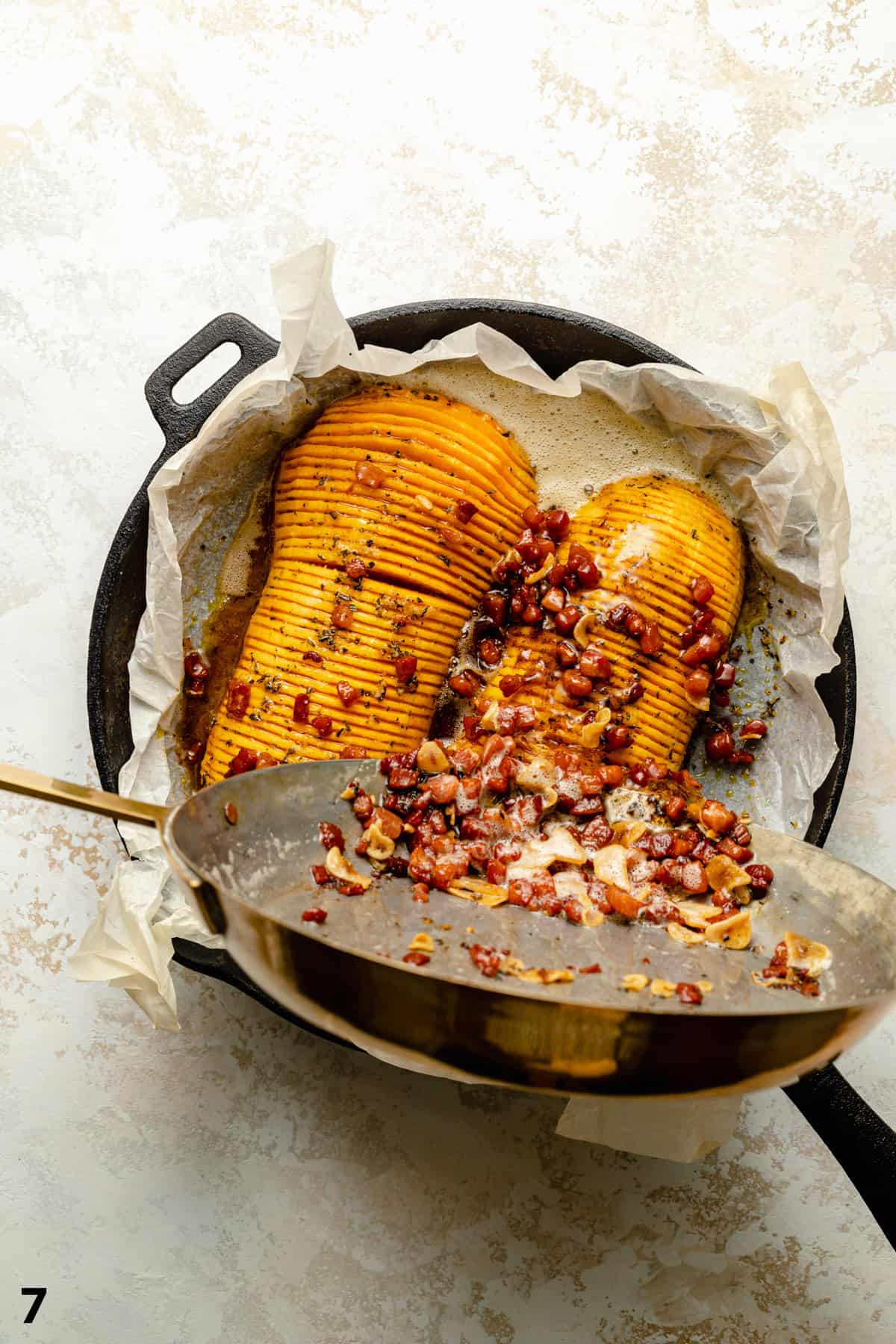 Pouring the bacon brown butter over the top of the roasted hasselback butternut squash. 