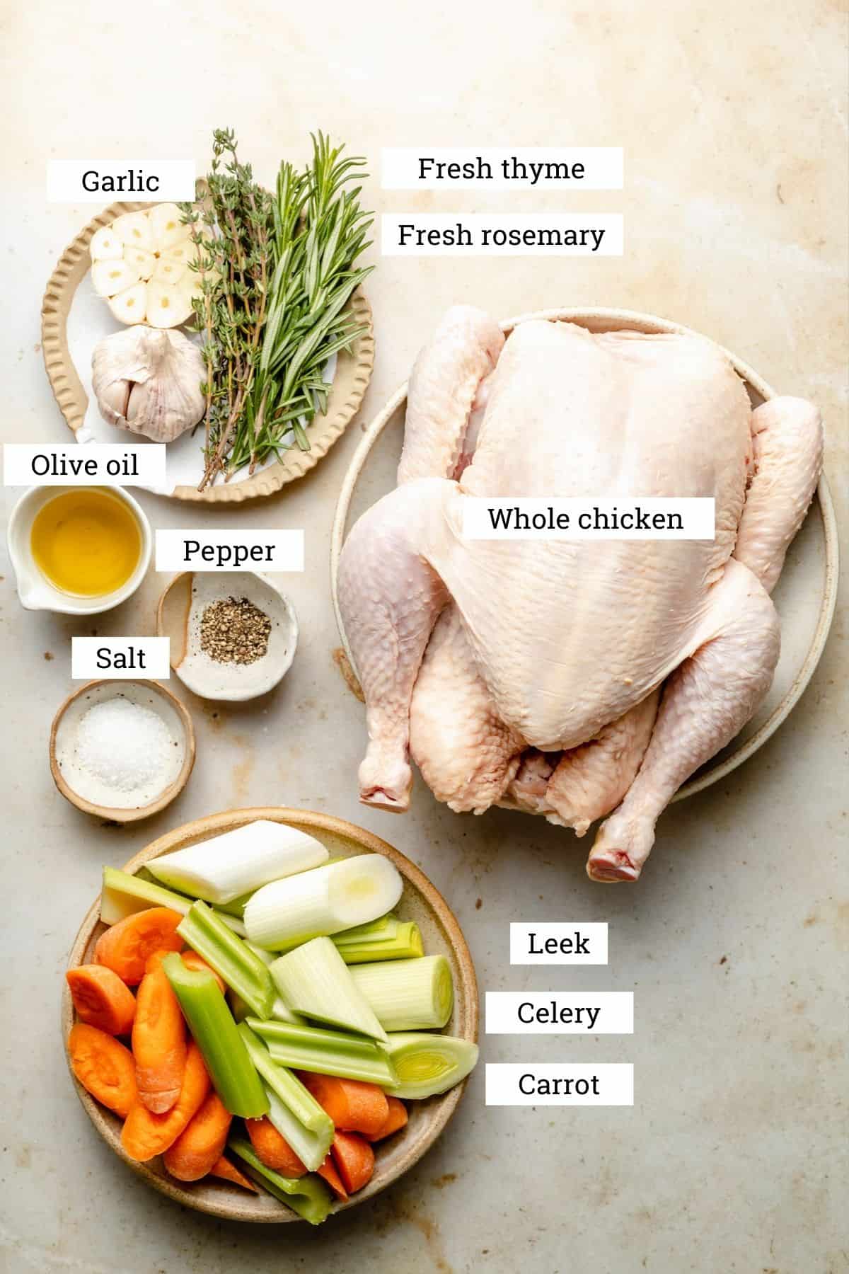 Ingredients in bowls: whole chicken, leek, celery, carrot, garlic, rosemary, thyme, oil, salt and pepper.