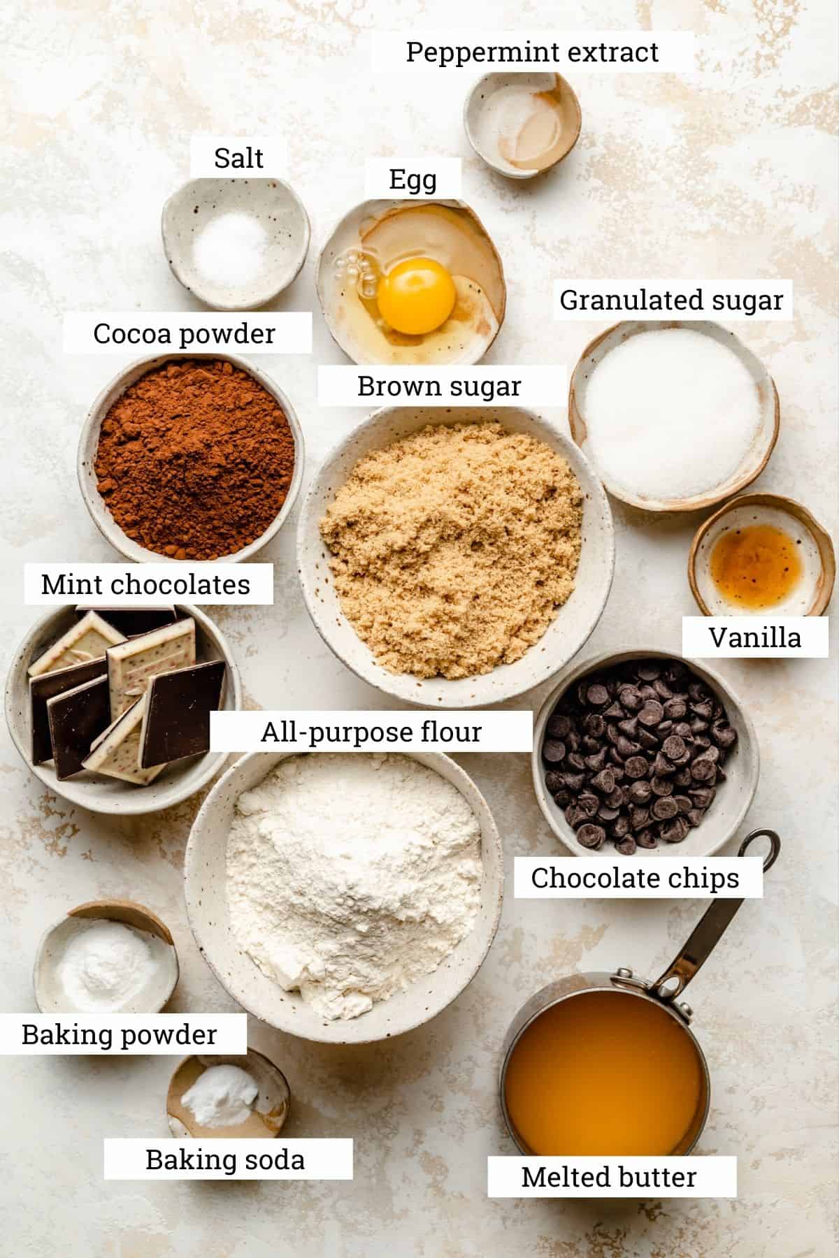Ingredients in various bowls for the chocolate chip mint cookies including peppermint bark.