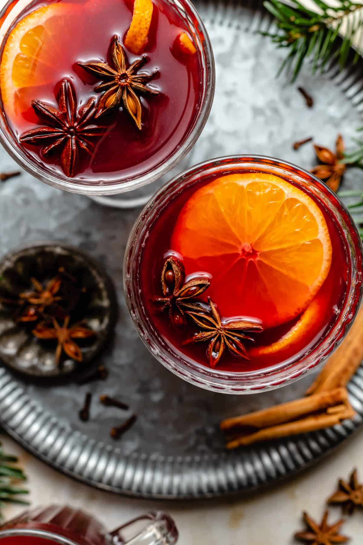Non Alcoholic Mulled wine in glasses on a tin tray with whole spices around by.