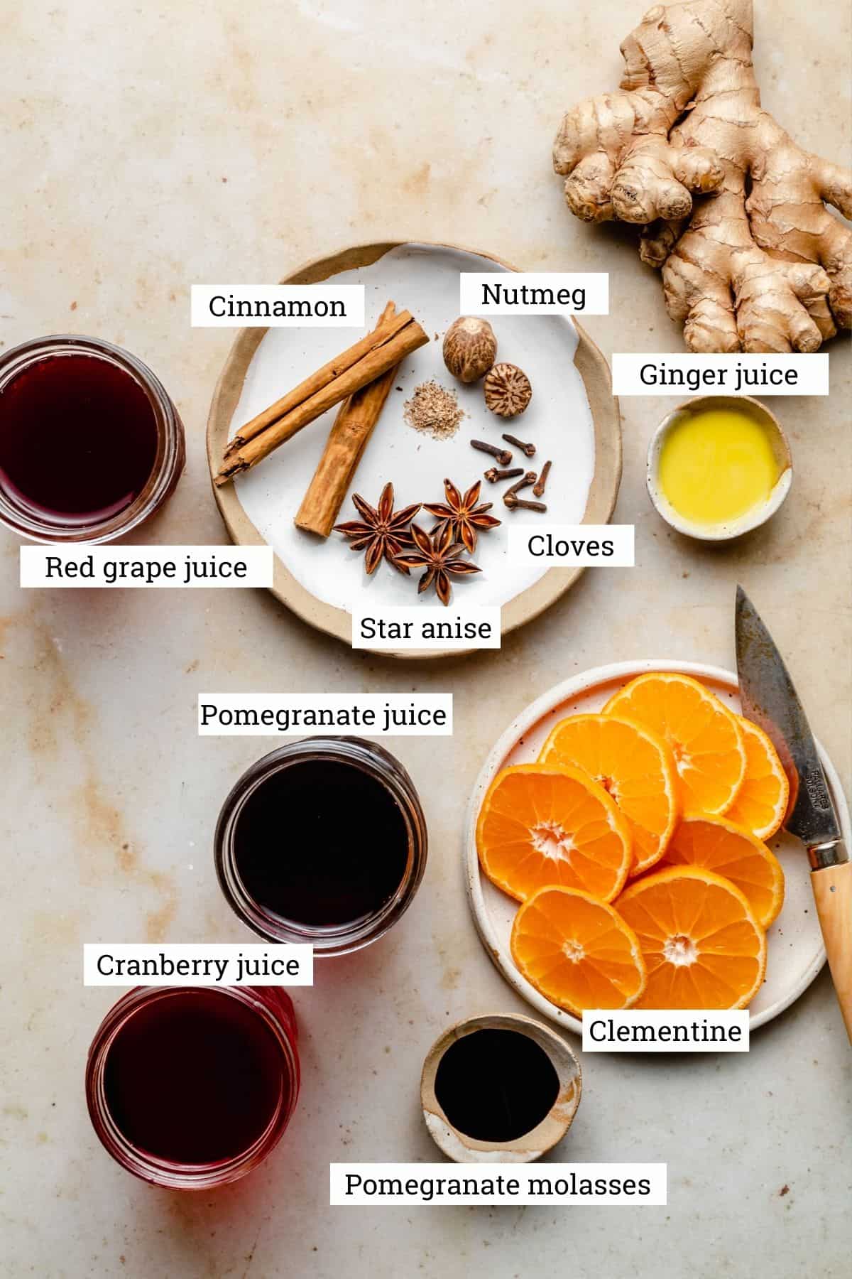 Ingredients for mulled wine including juices, spices, clementine, pomegranate molasses and ginger.