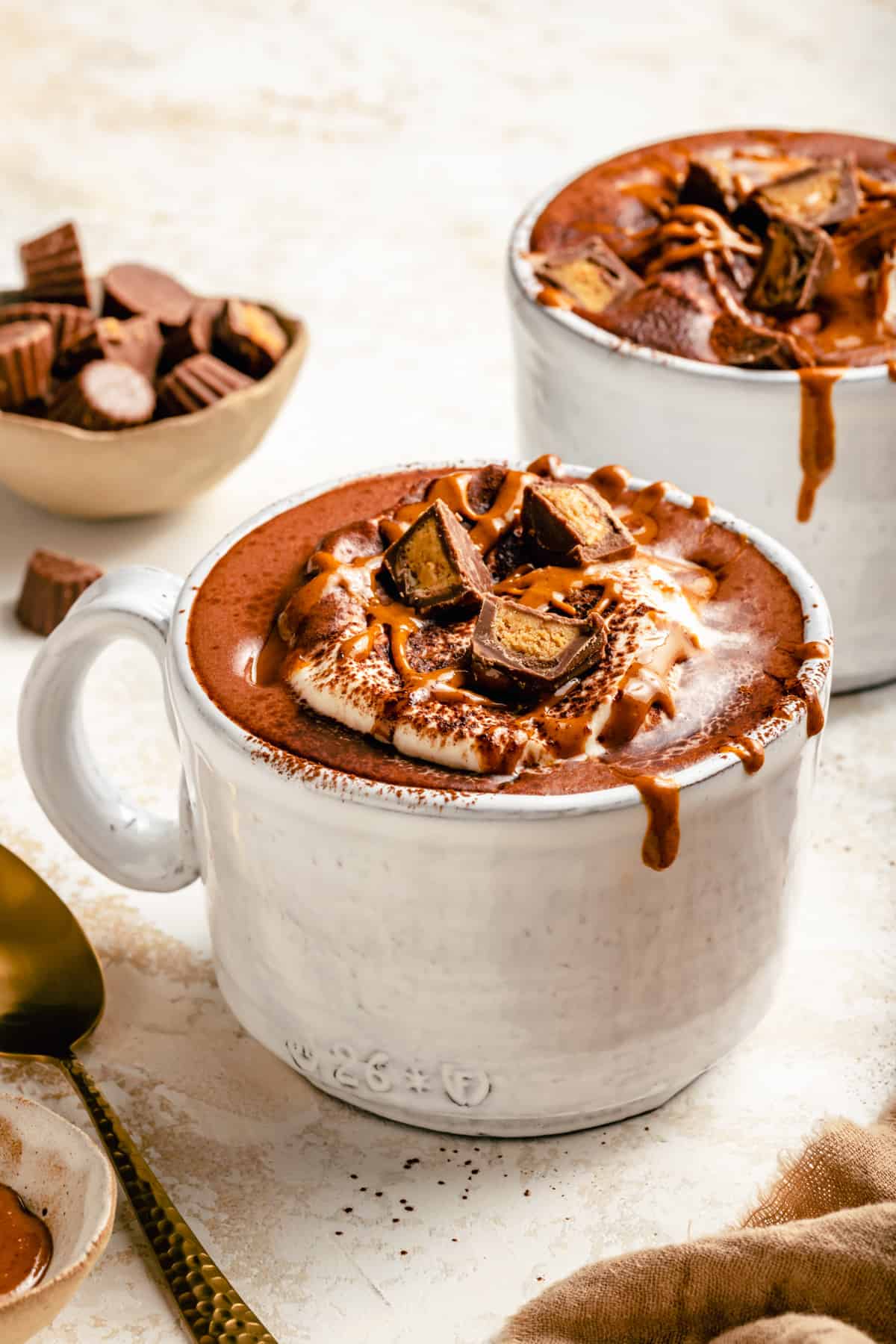 Peanut butter hot chocolate in a mug with peanut butter dripping down the side.