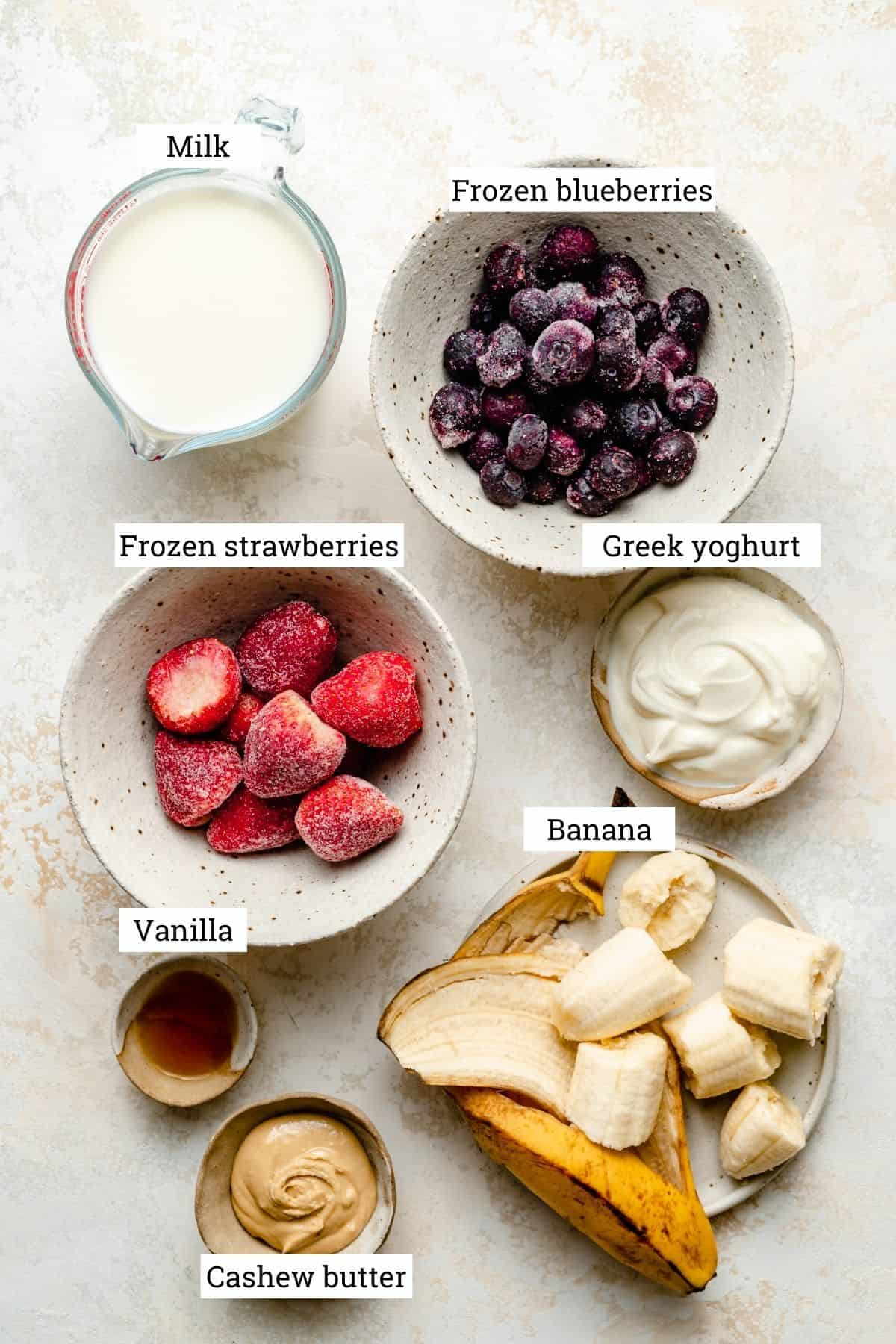 Ingredients in various bowls for the strawberry blueberry smoothie.