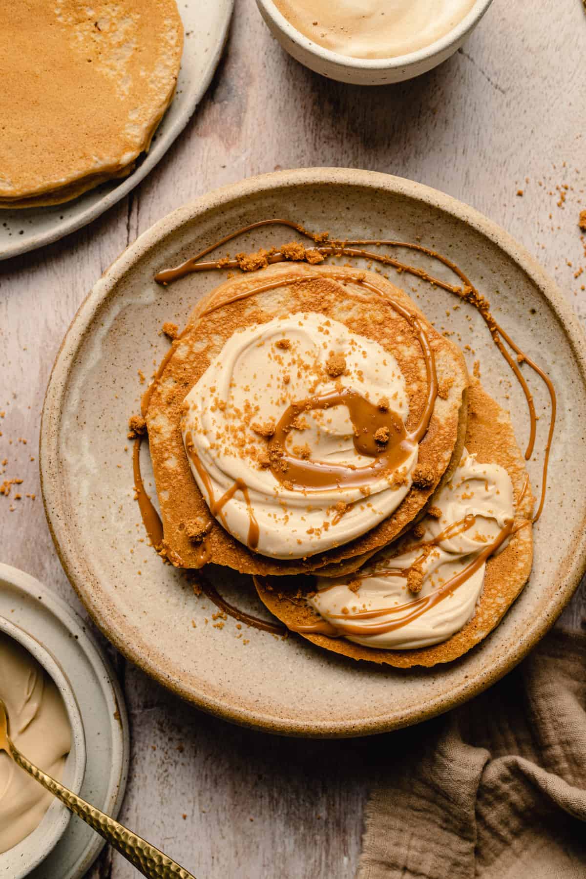 Two pancakes served on a place with whipped biscoff cream in a breakfast setting.