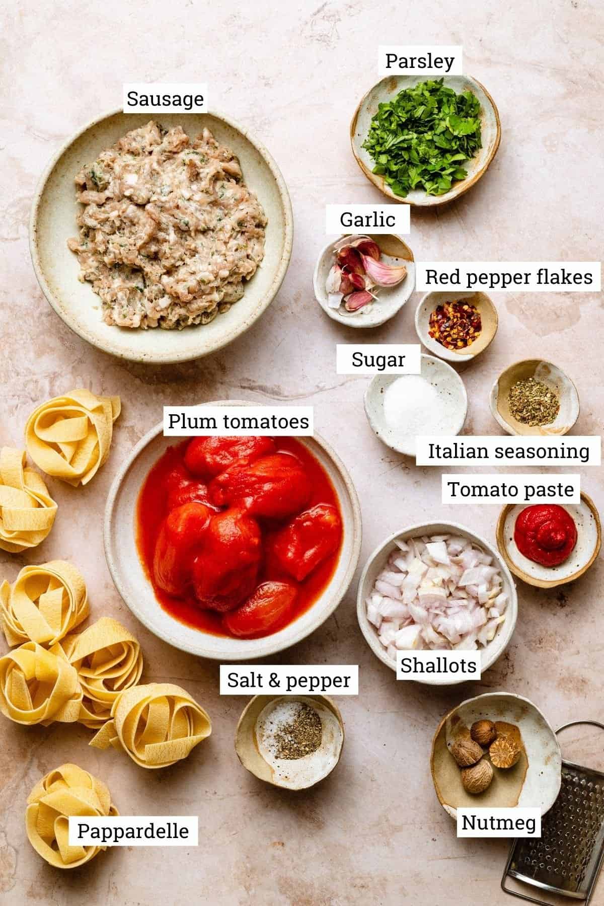 Ingredients for sausage ragu in various bowls.