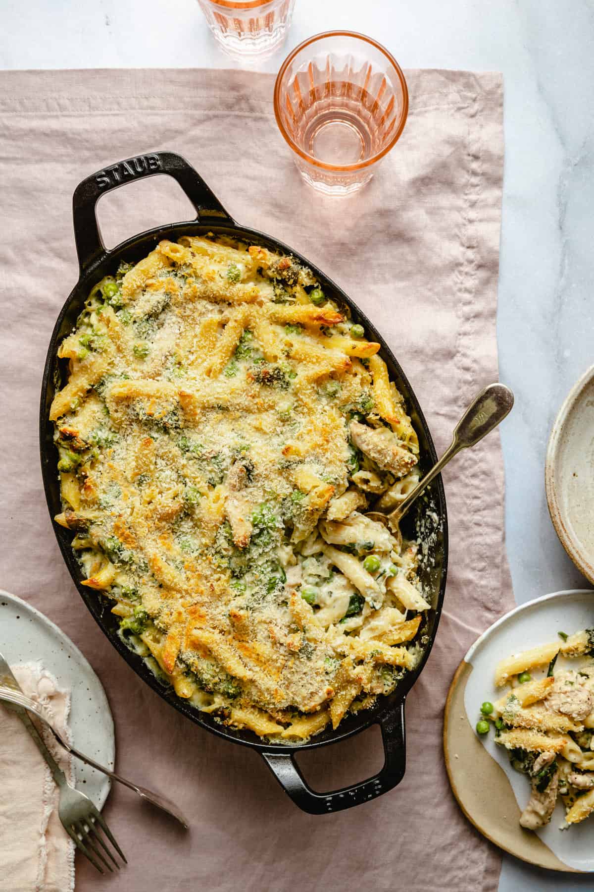 baked creamy chicken pasta bake with a spoon serving it up showing the creaminess.