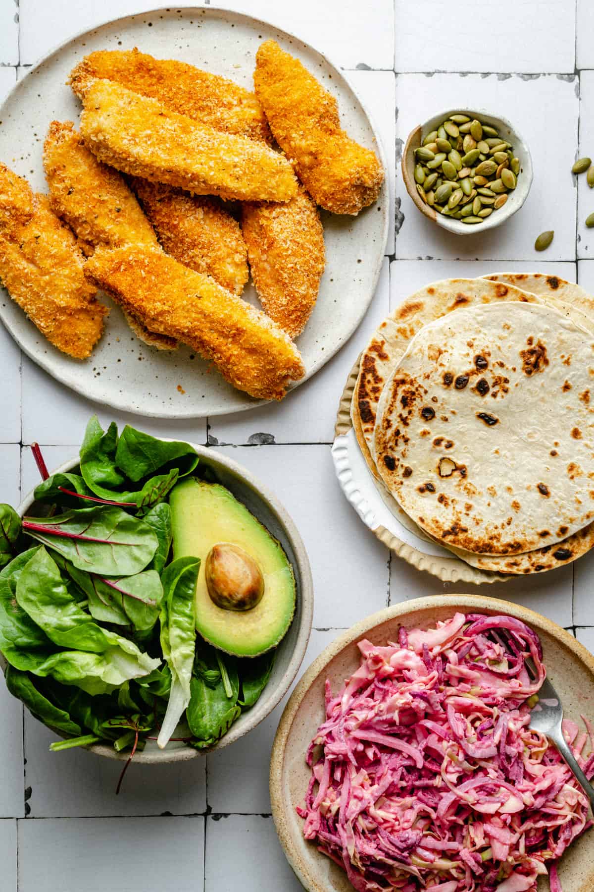 A layout of the fillings for the crispy chicken tacos on plates ready to assemble.