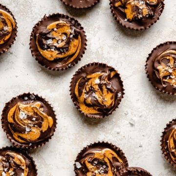 An array of almond butter cups with almond butter swirl and salt flakes on top.