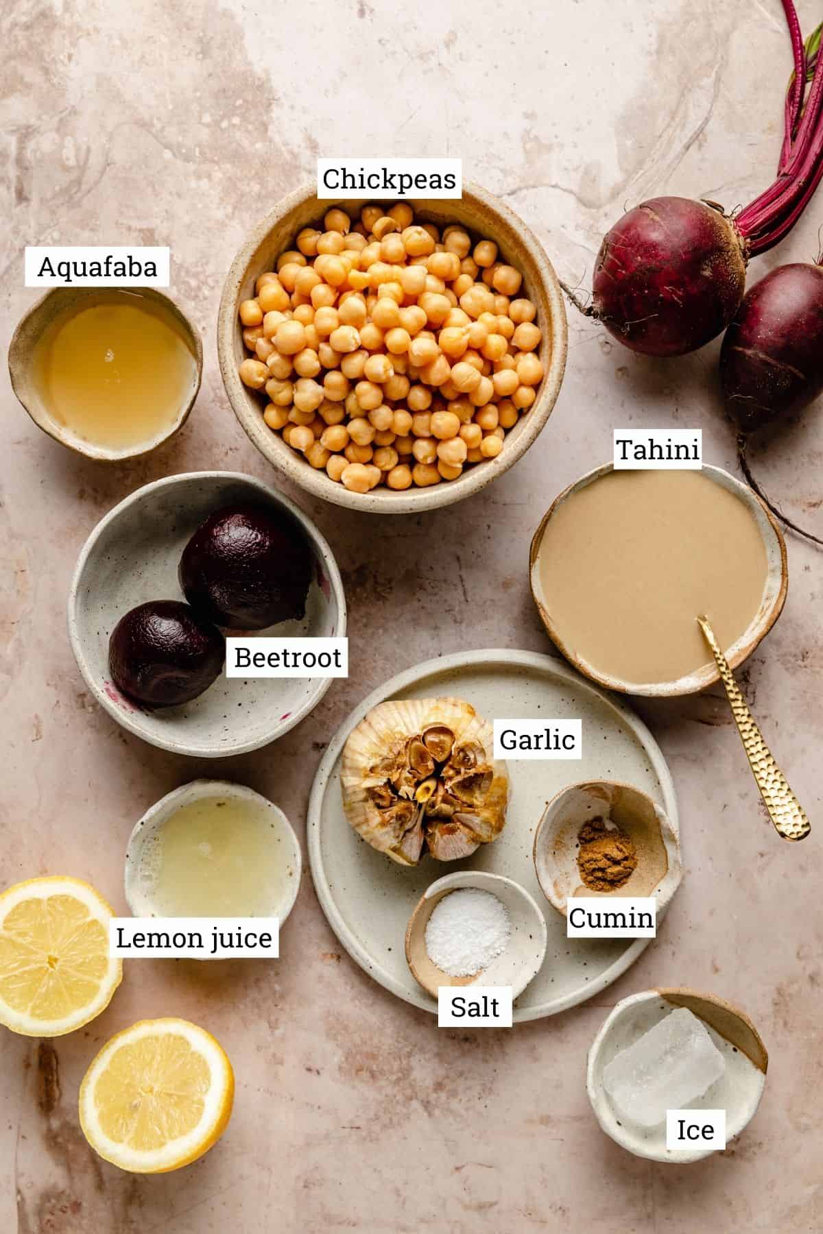 Ingredients for hummus in various bowls with labels.