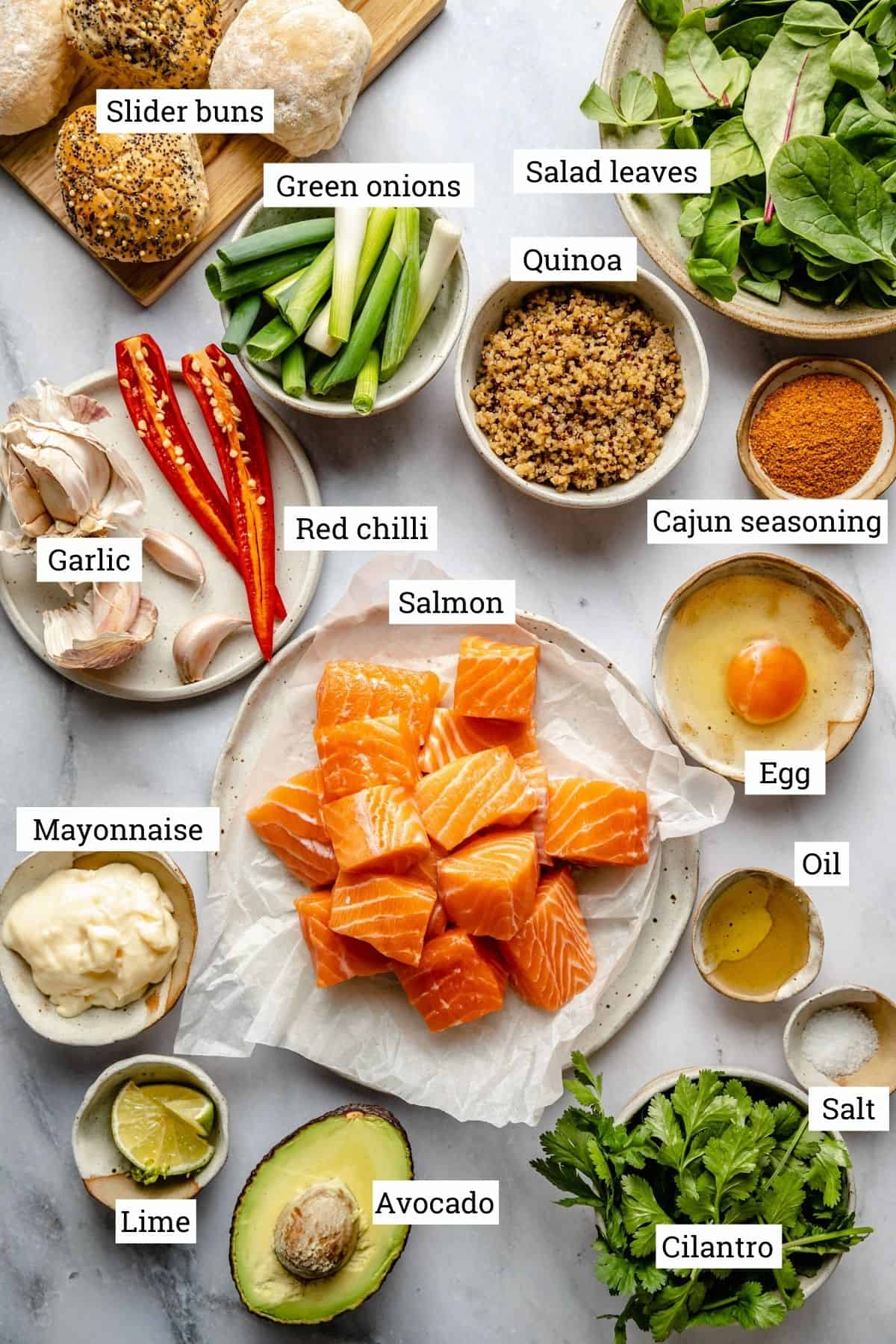 Ingredients for salmon sliders on marble surface with labels.