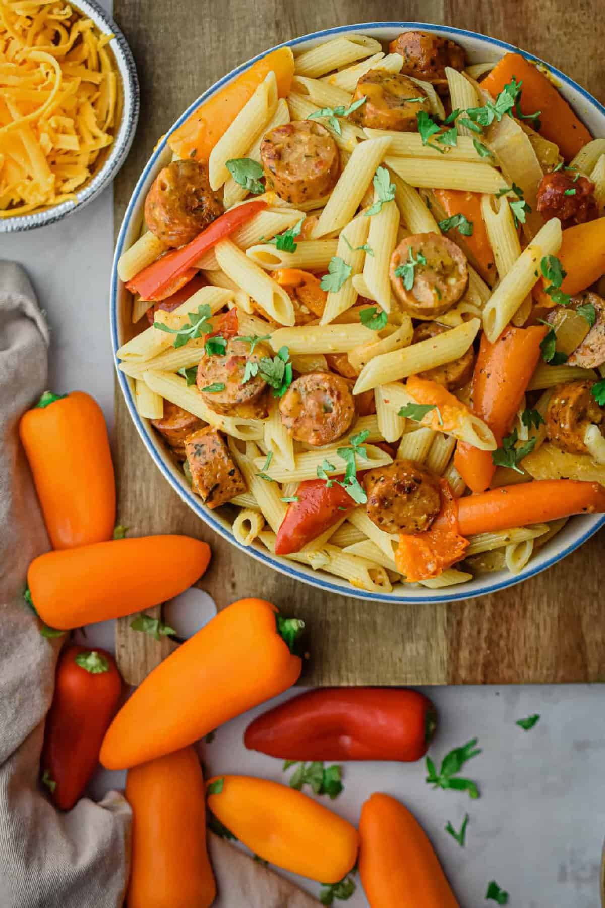 Chicken Sausage and mini pepper paster in a bowl with cheese to the side.