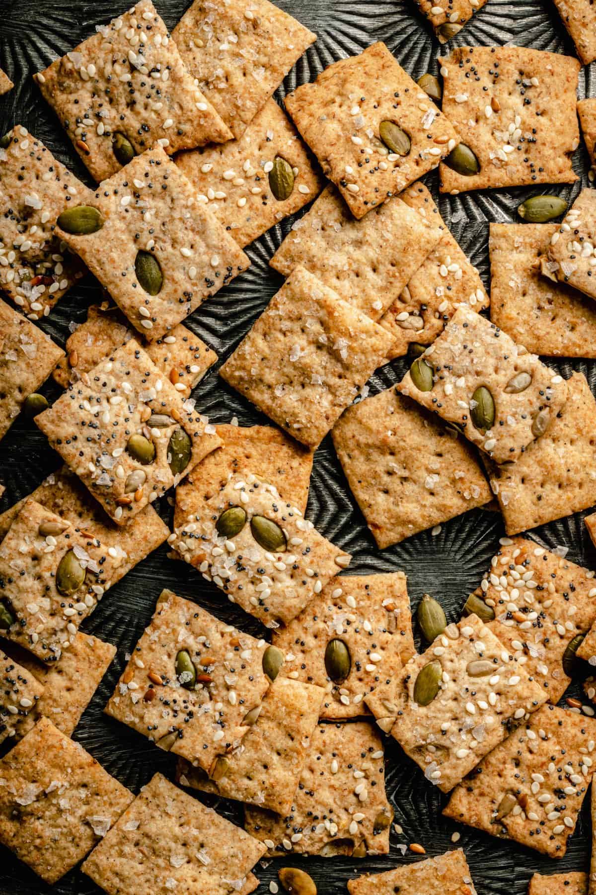 Close up of sourdough crackers on a metal tray.