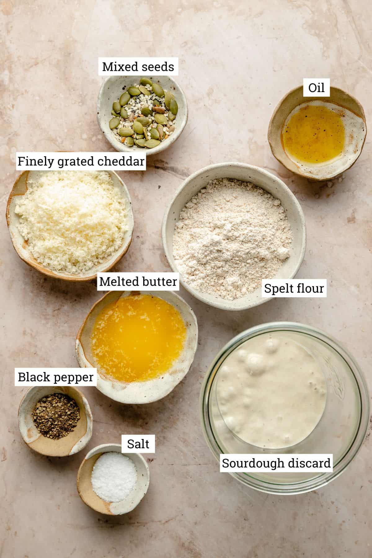 Ingredients in various bowls for sourdough discard crackers.