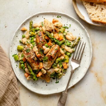 A plate with cream chicken sausage skillet served with a fork and bread.