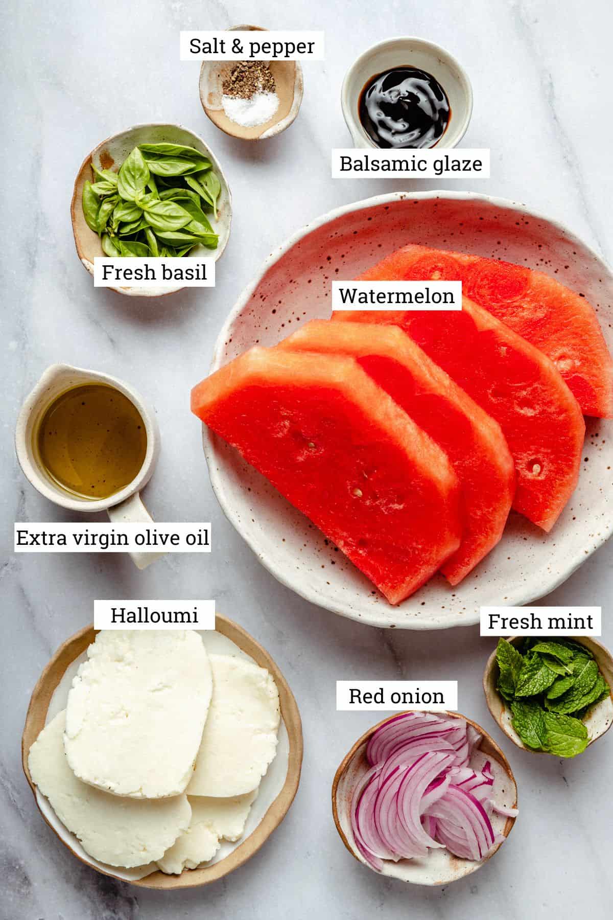 Ingredients in various bowls for the watermelon salad, labelled.