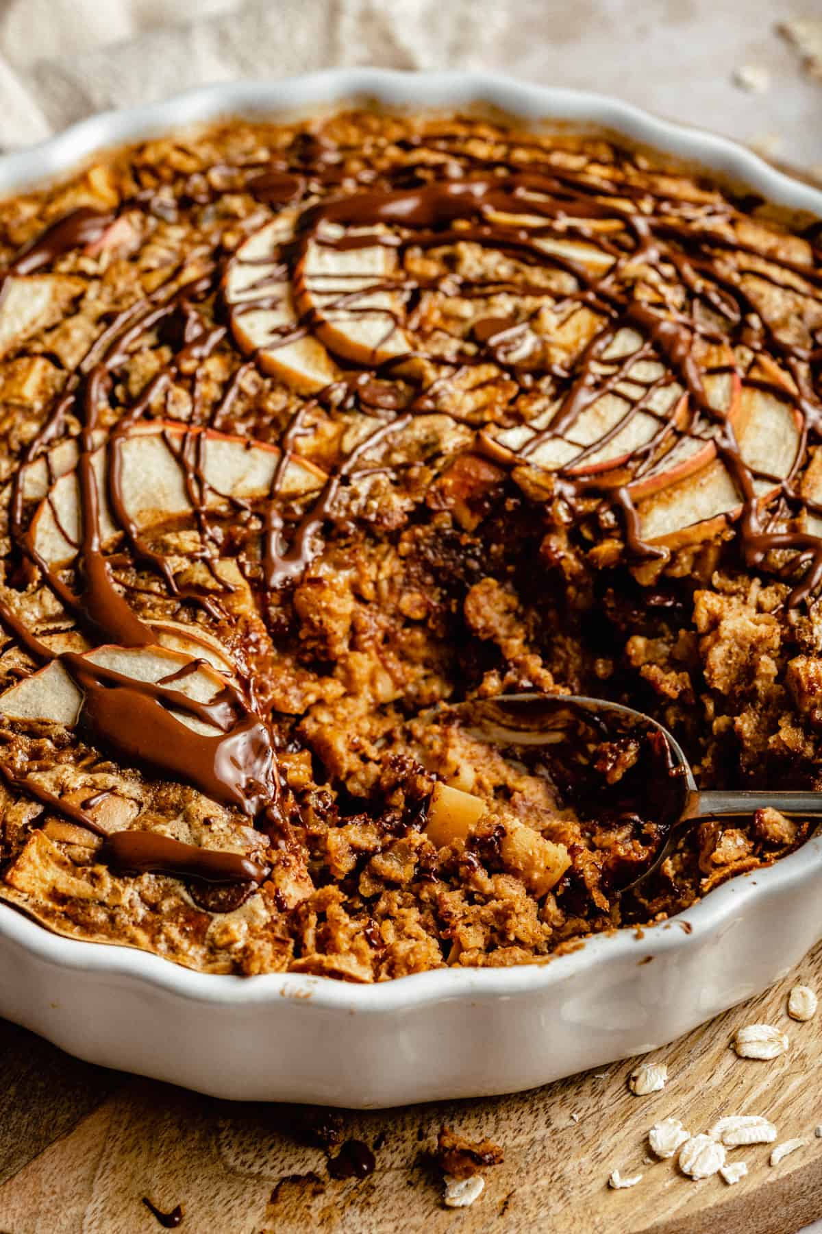 Close up of a spoon serving in a baked oatmeal dish having served up a portion.