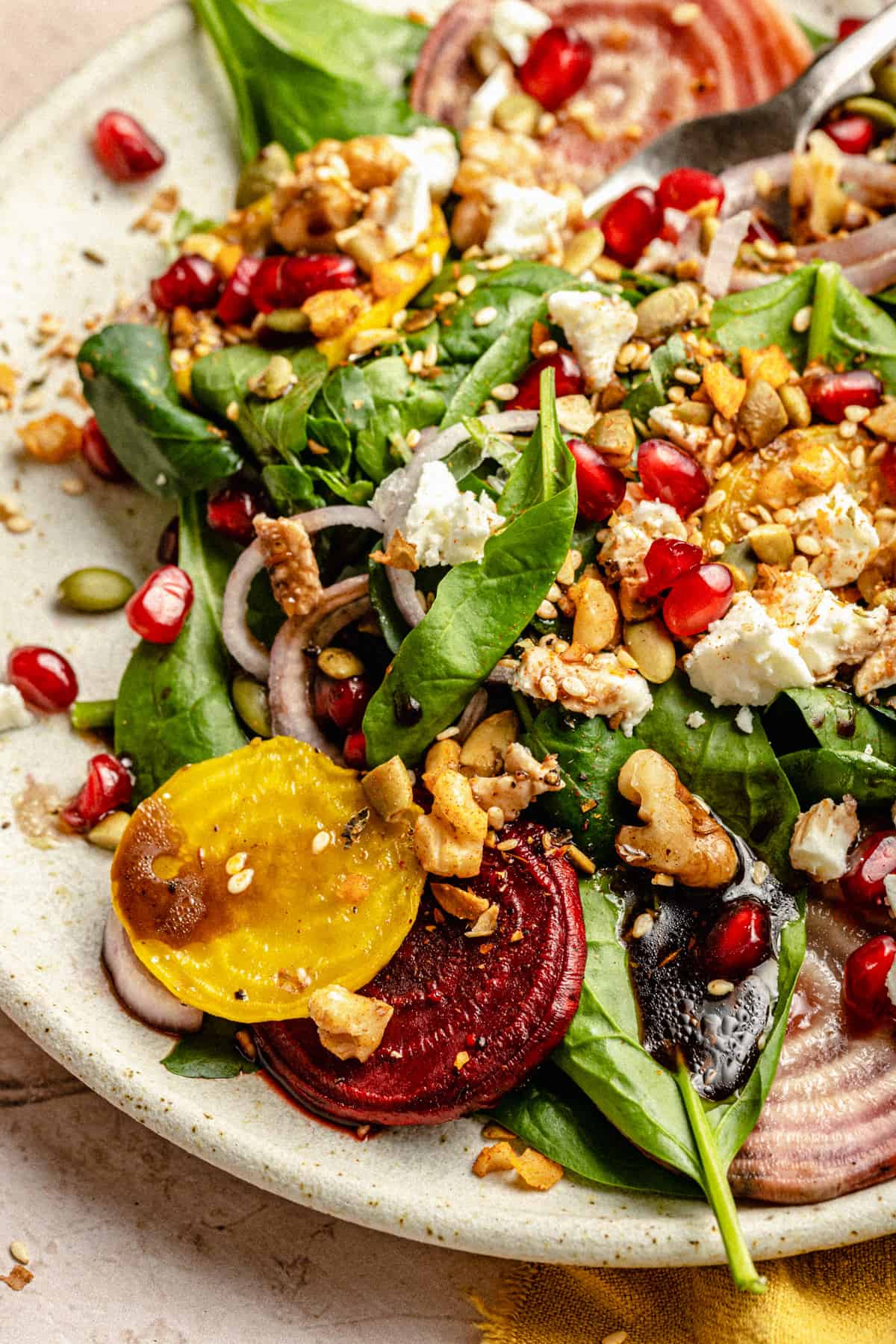 Close up of roasted beetroot feta walnut salad with walnuts and dukkah on a plate.