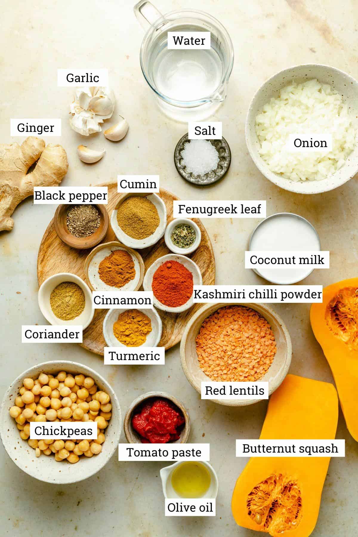 Ingredients for the curry in various bowls with labels, including butternut squash and chickpeas.