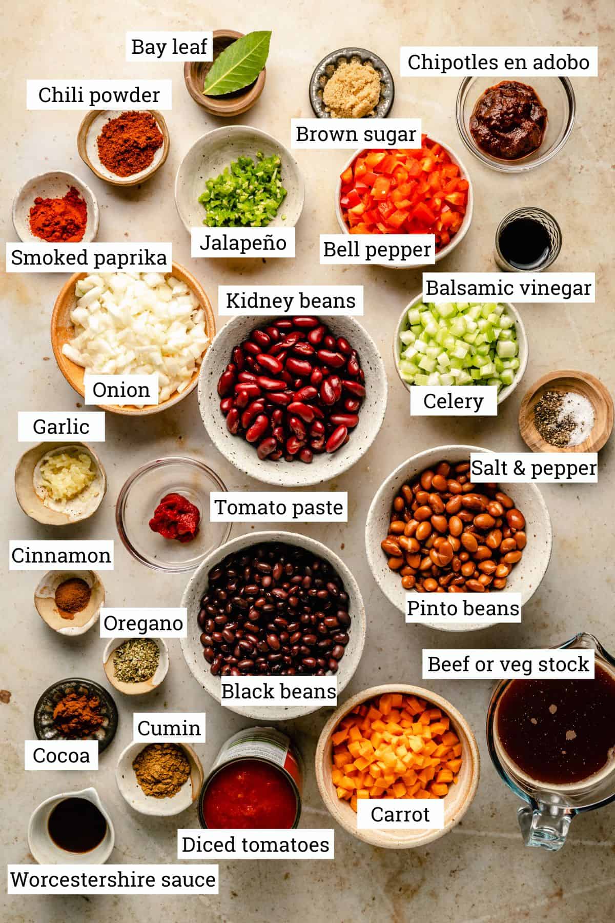 Ingredients for the chili in various bowls on a work surface labeled.