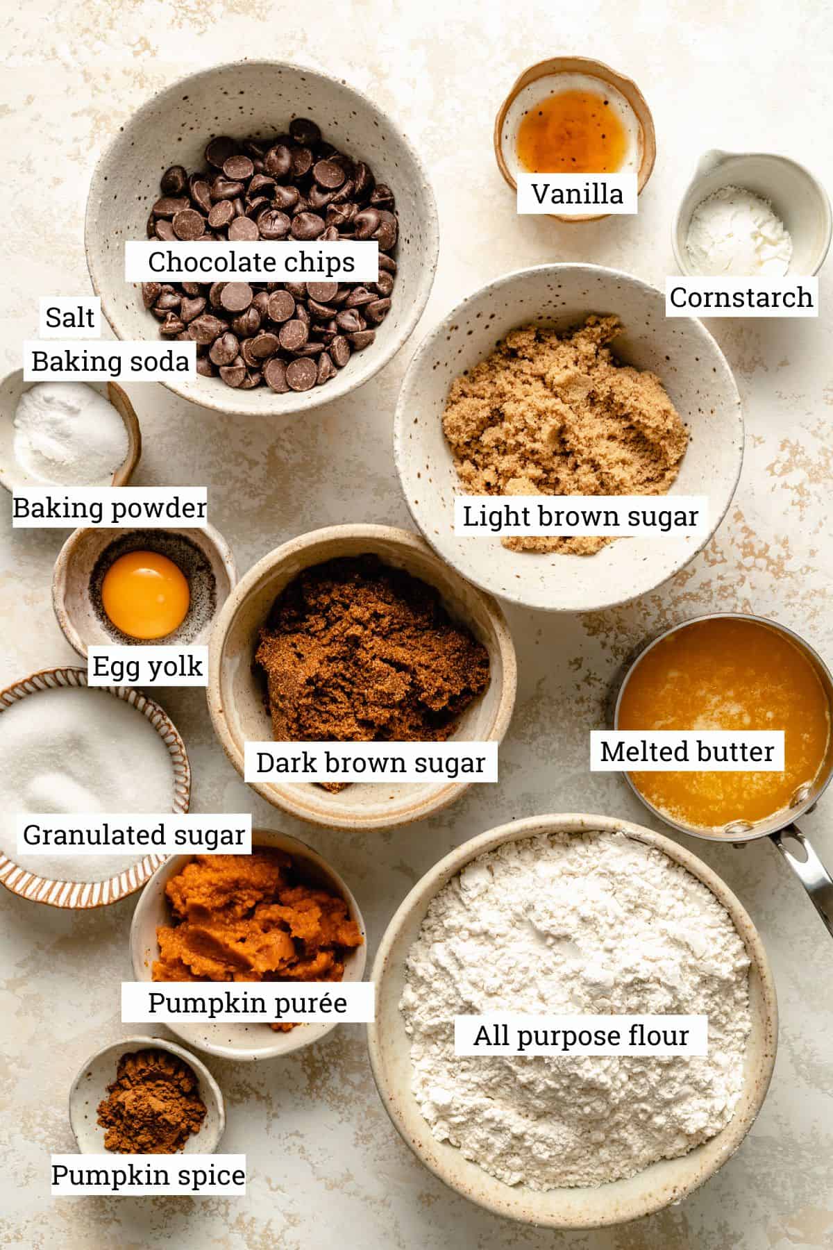 Ingredients in various bowls for cookies, including flour, sugar, eggs and butter.