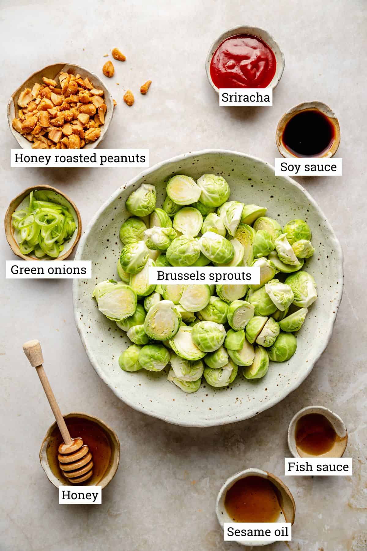 Ingredients for sriracha brussels sprouts in various bowls on a worksurface.