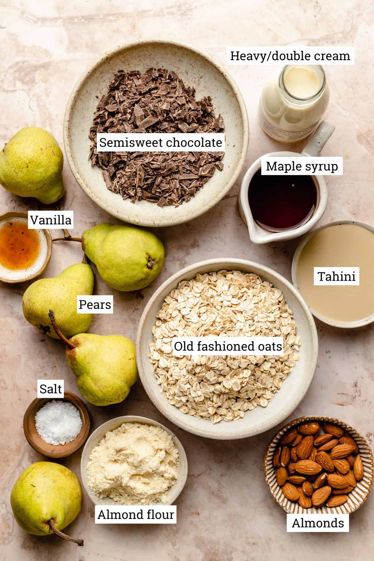 Various bowls of ingredients needed for the recipe, including pears and oats.