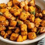 Easy roasted swede with herbs in a bowl with a spoon.