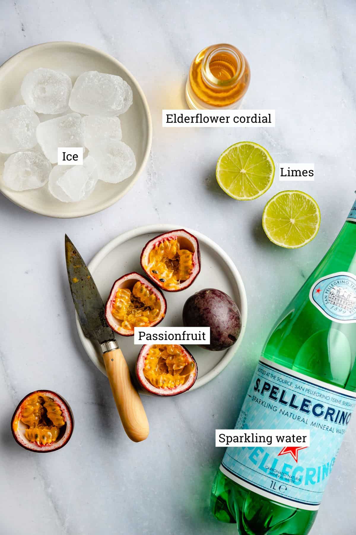 Passionfruit mocktail ingredients on a marble surface. 