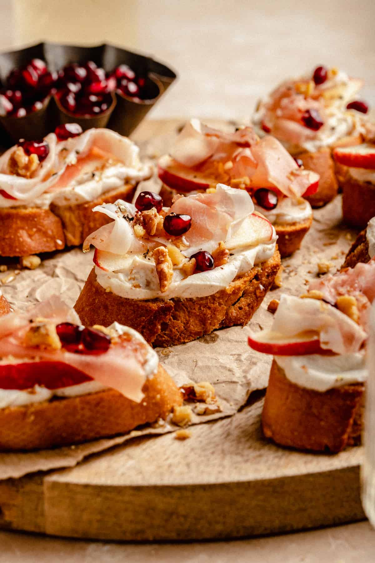 Close up showing the layers of the ricotta crostini toppings on a board.