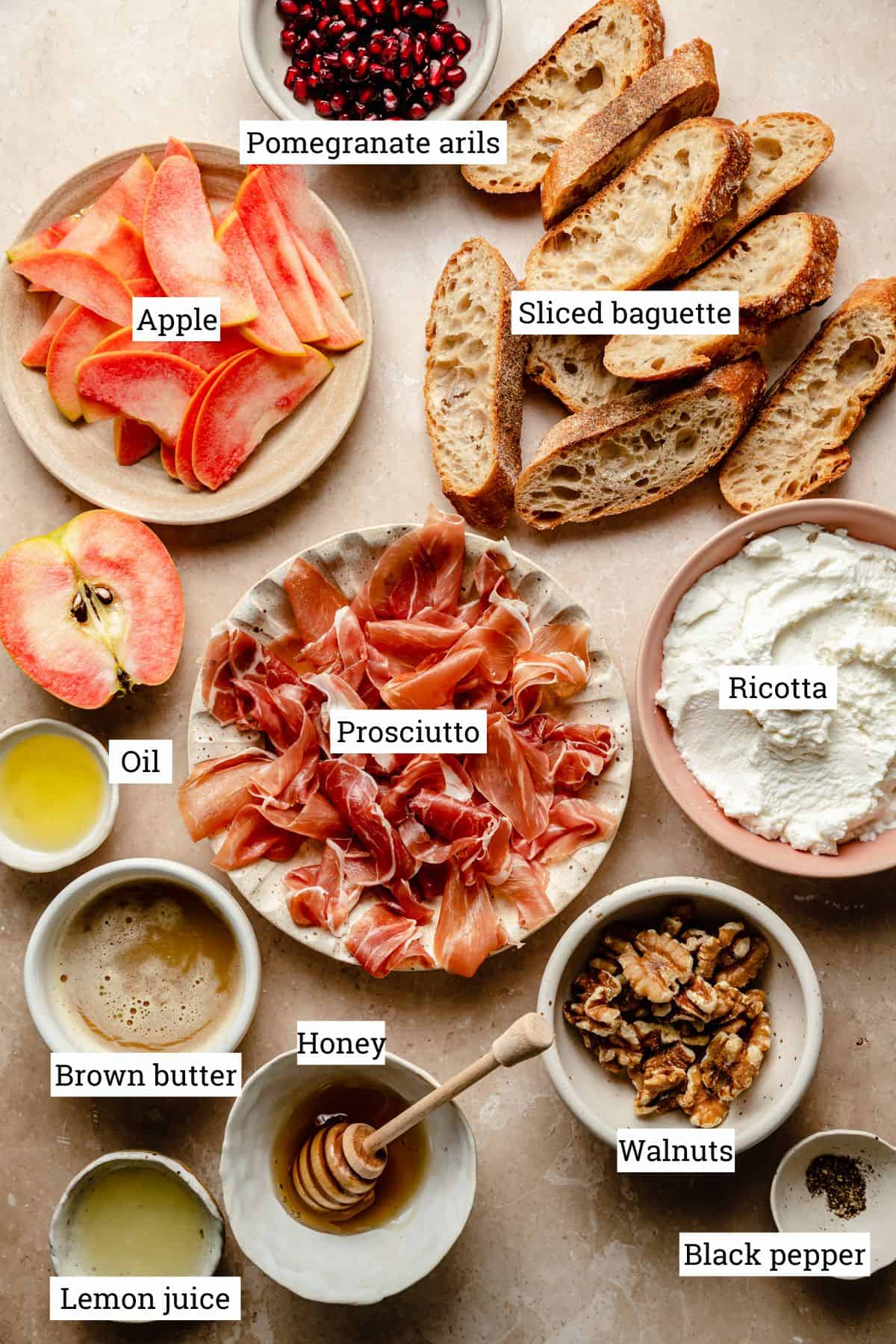 Ingredients for crostini in various bowls on a work surface.