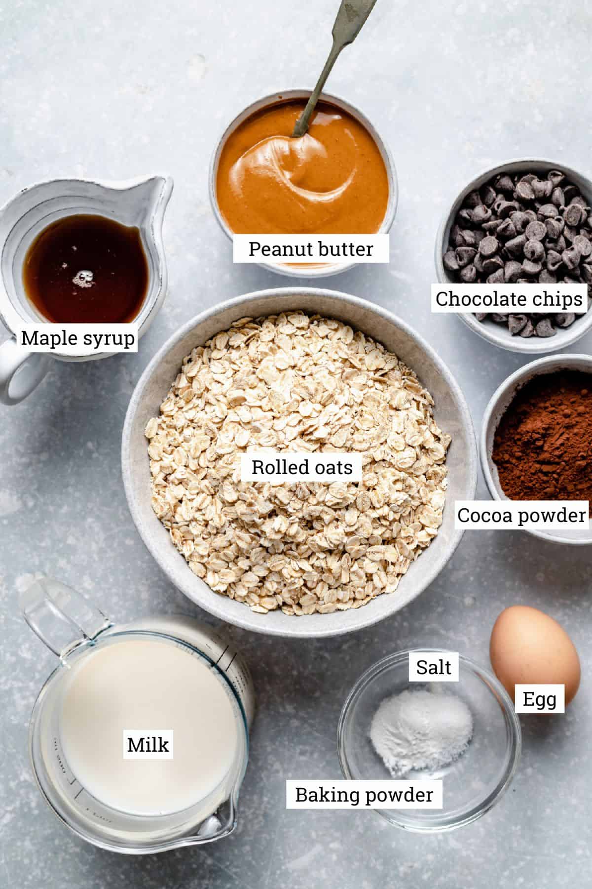 Ingredients for chocolate peanut butter baked oatmeal labelled in bowls.