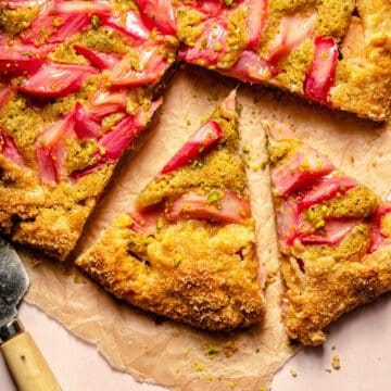 Rhubarb galette on brown parchment cut into wedges with a knife to the edge.